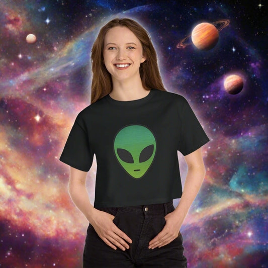 Person wearing a black t-shirt with a green alien face design on a white background
